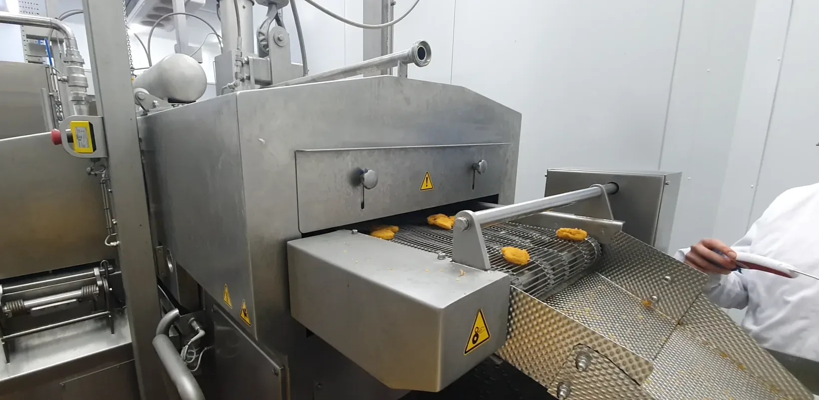 Técnico comprobando nuggets a la salida de una línea de producción